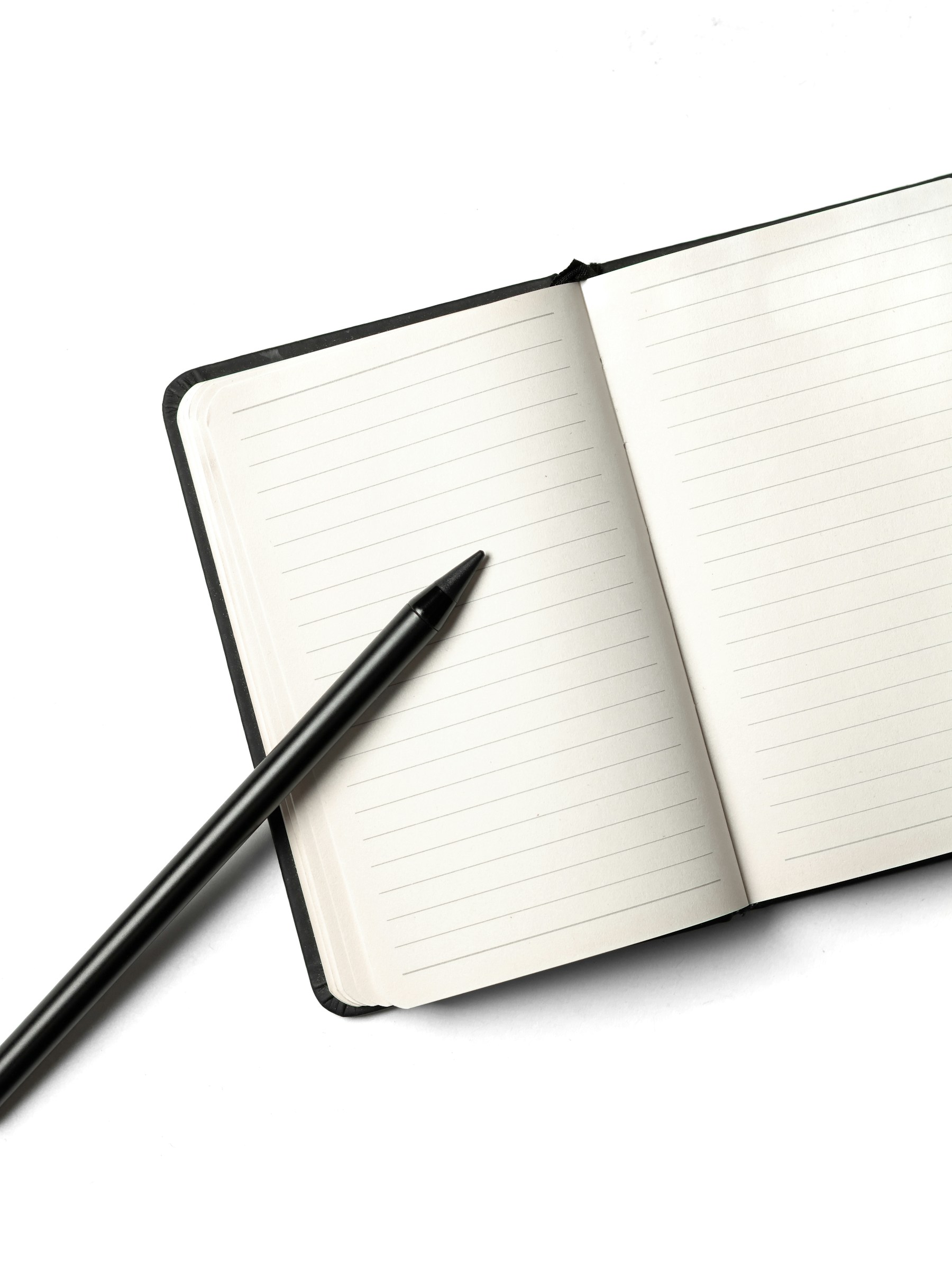 An open notebook with a pencil resting across its pages
